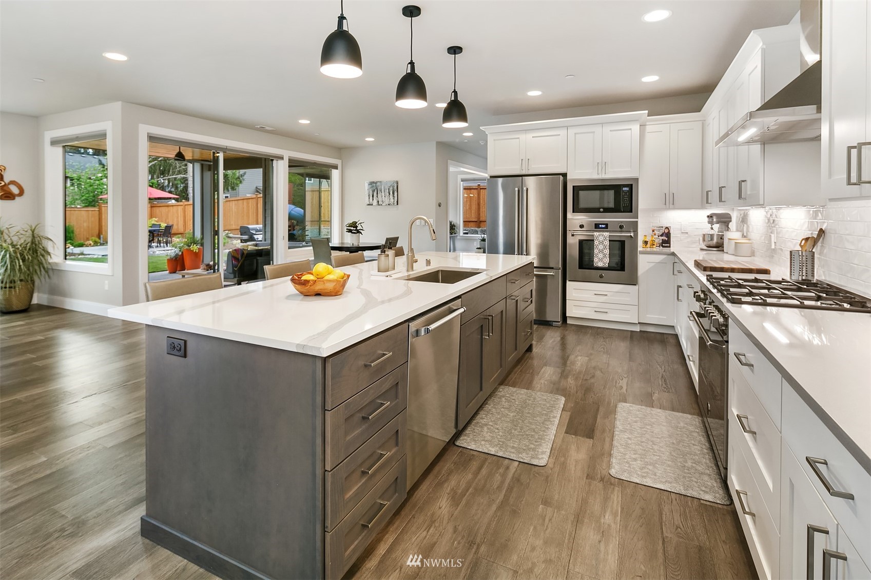 236 234th Place Southeast Bothell, WA 98021 - Photo 16 of 39 a kitchen with a stove a sink dishwasher a refrigerator and white cabinets with wooden floor
