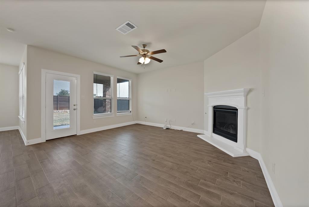 10401 Table Blf Street Aubrey, TX 76227 - Photo 6 of 25 an empty room with chandelier fan and windows