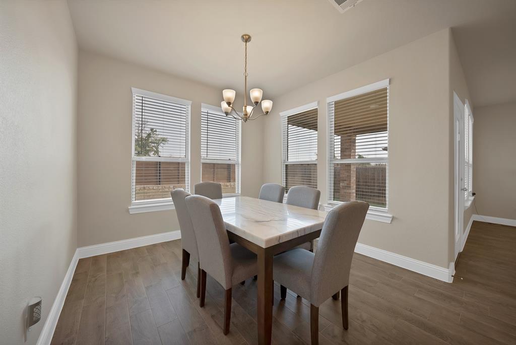 10401 Table Blf Street Aubrey, TX 76227 - Photo 8 of 25 a view of a dining room with furniture wooden floor and chandelier
