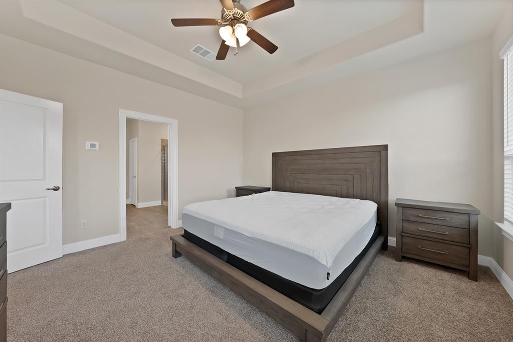 10401 Table Blf Street Aubrey, TX 76227 - Photo 10 of 25 a bedroom with a bed and a chandelier
