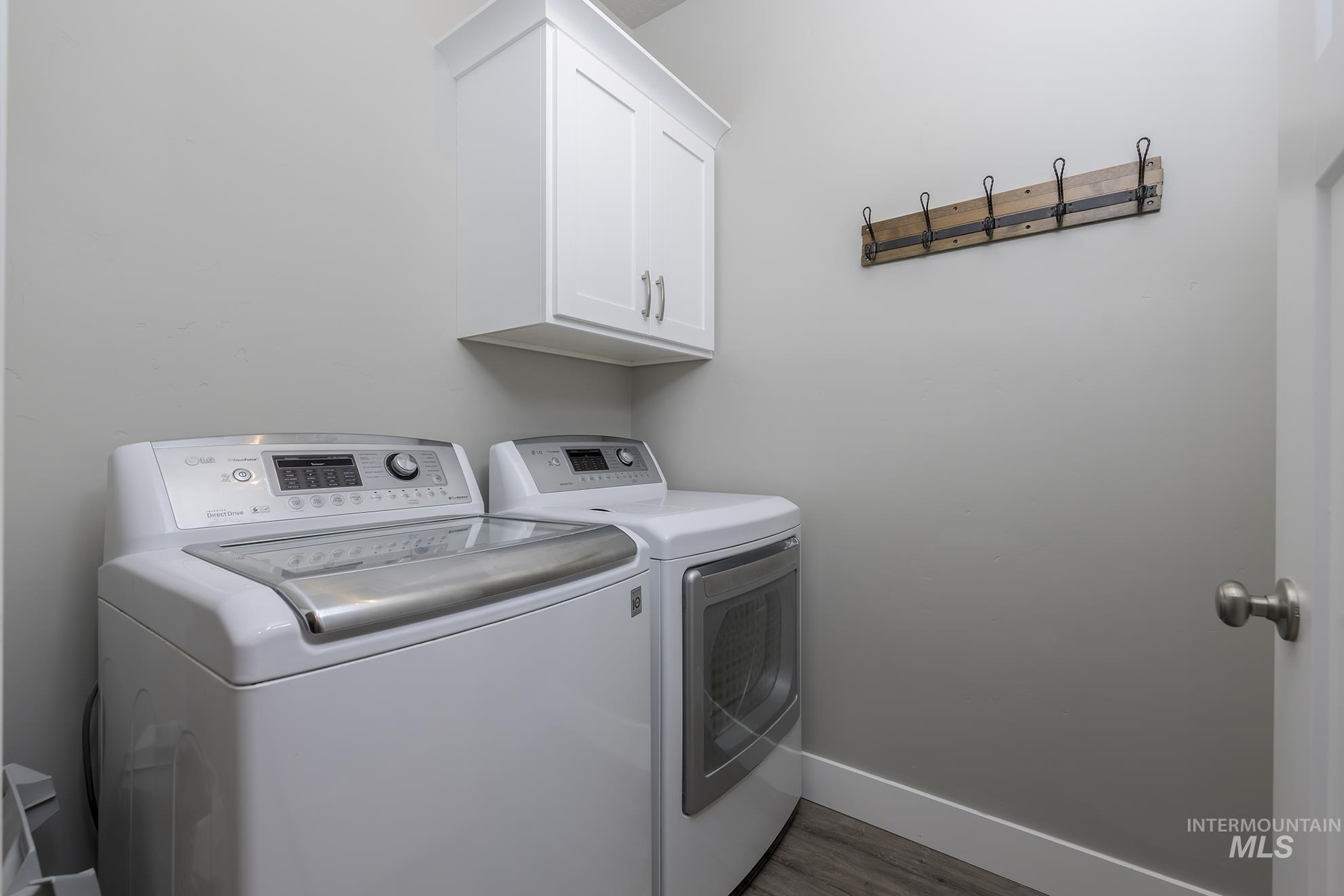2808 Tamarack Street Fruitland, ID 83619 - Photo 19 of 36 Laundry room featuring washer and clothes dryer, light wood-type flooring, and cabinet space