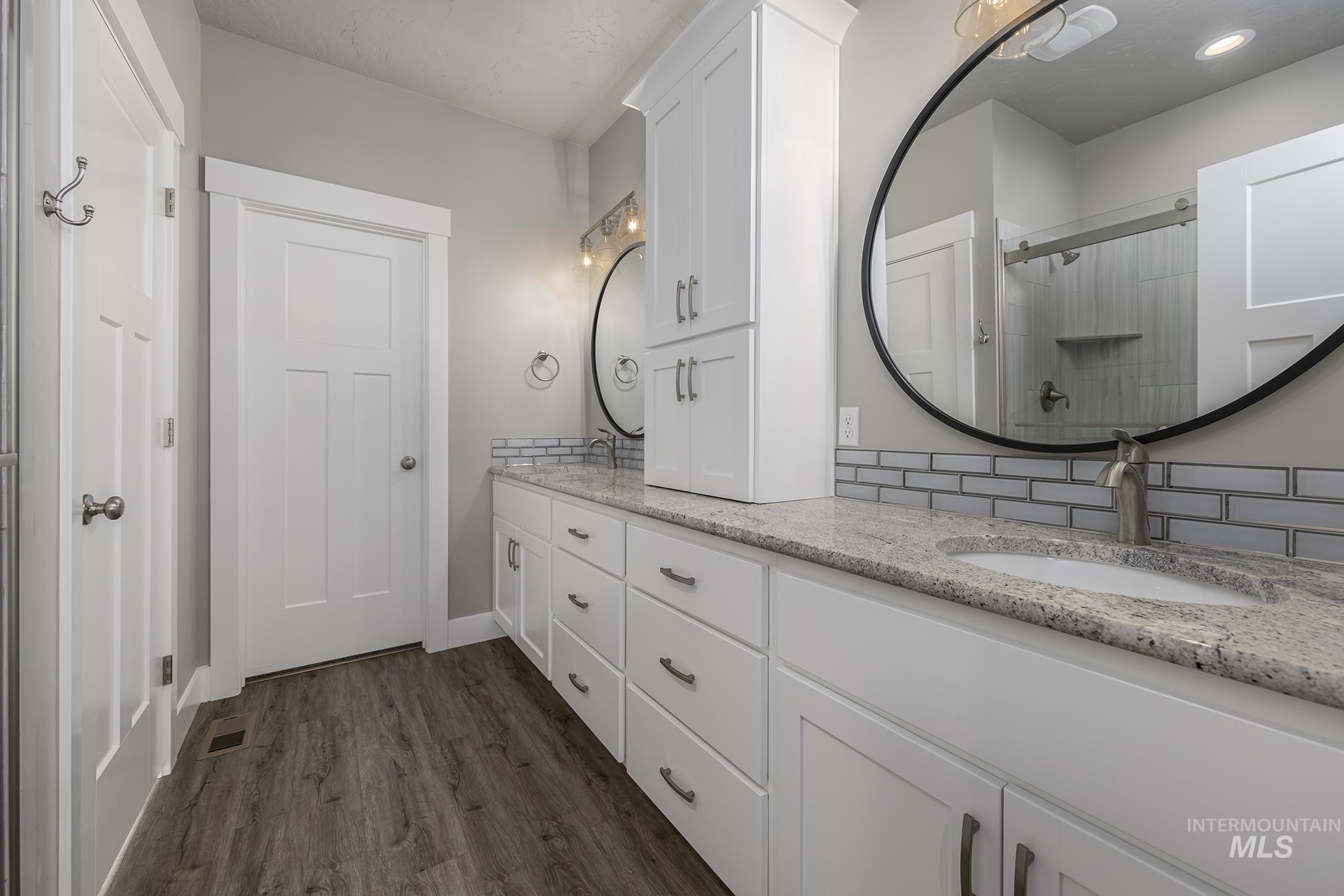 2808 Tamarack Street Fruitland, ID 83619 - Photo 21 of 36 Full bathroom with double vanity, dark wood-style floors, and a stall shower