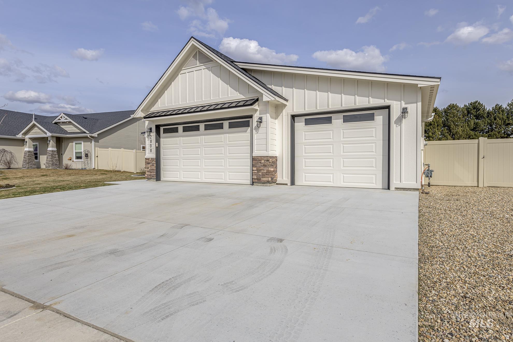 2808 Tamarack Street Fruitland, ID 83619 - Photo 5 of 36 View of front of property featuring a gate, driveway, board and batten siding, a garage, and a standing seam roof