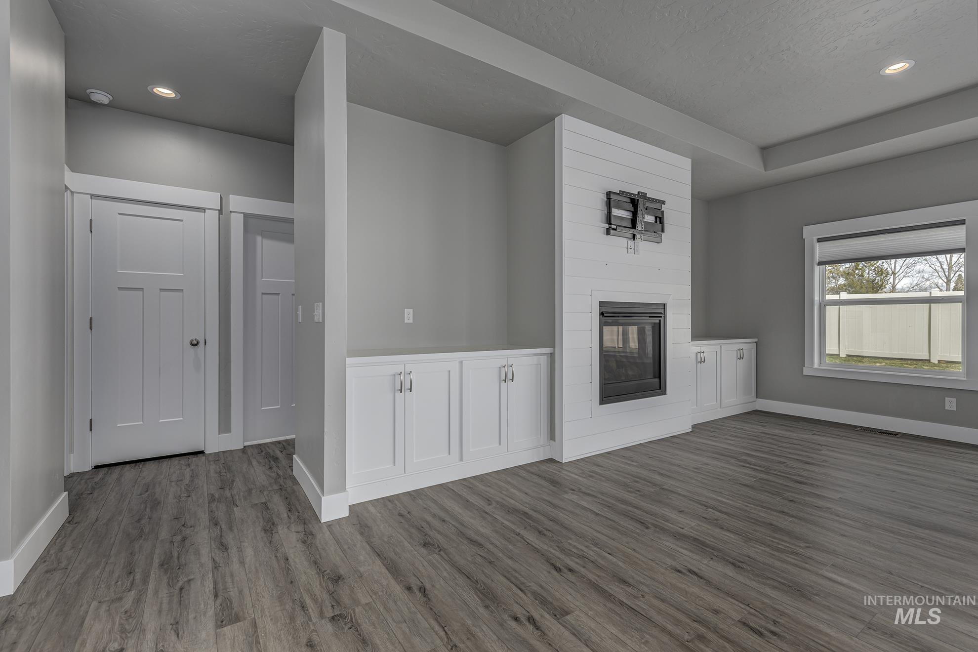 2808 Tamarack Street Fruitland, ID 83619 - Photo 7 of 36 Unfurnished living room featuring recessed lighting, a fireplace, and dark wood finished floors