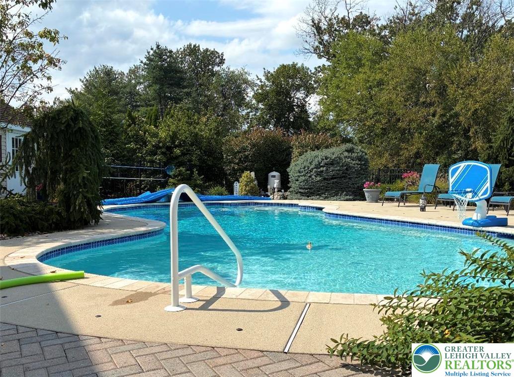 4059 Old Sentry Road Allentown, PA 18104 - Photo 34 of 39 An inviting pool area, framed by lush greenery, offers a private oasis for leisure.
