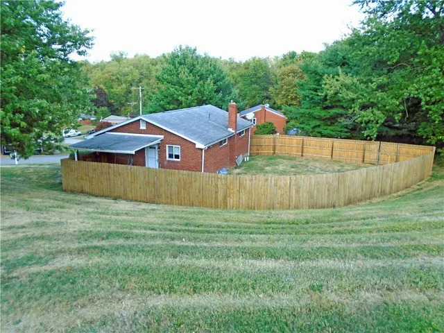 a house that has a big yard and wooden fence