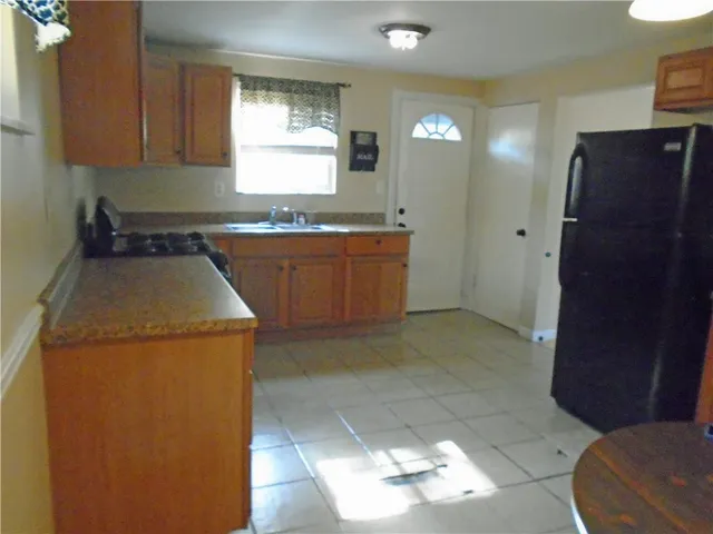 a kitchen with a sink a refrigerator and cabinets
