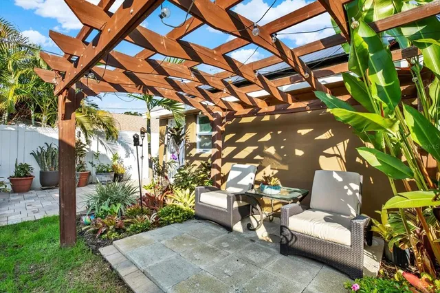 a view of a patio with couches and table and chairs and potted plants