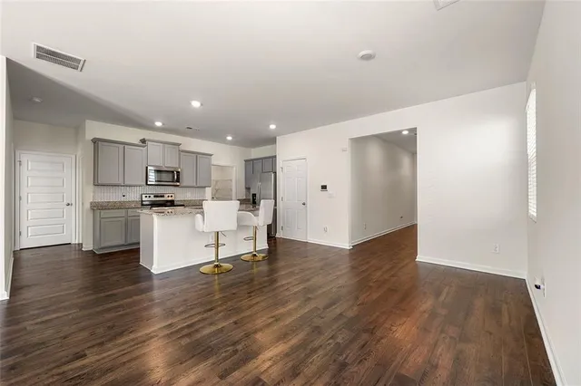 a view of kitchen view wooden floor and white cabinets