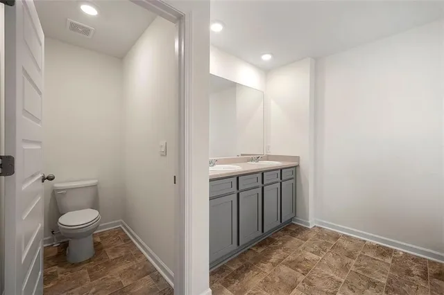 a bathroom with a toilet sink and mirror