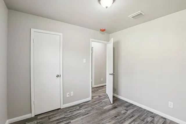 an empty room with wooden floor and door
