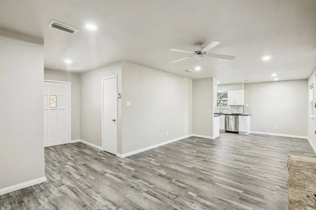 a view of a kitchen with wooden floor and a ceiling fan