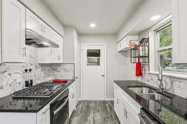 a kitchen with granite countertop a stove and a sink
