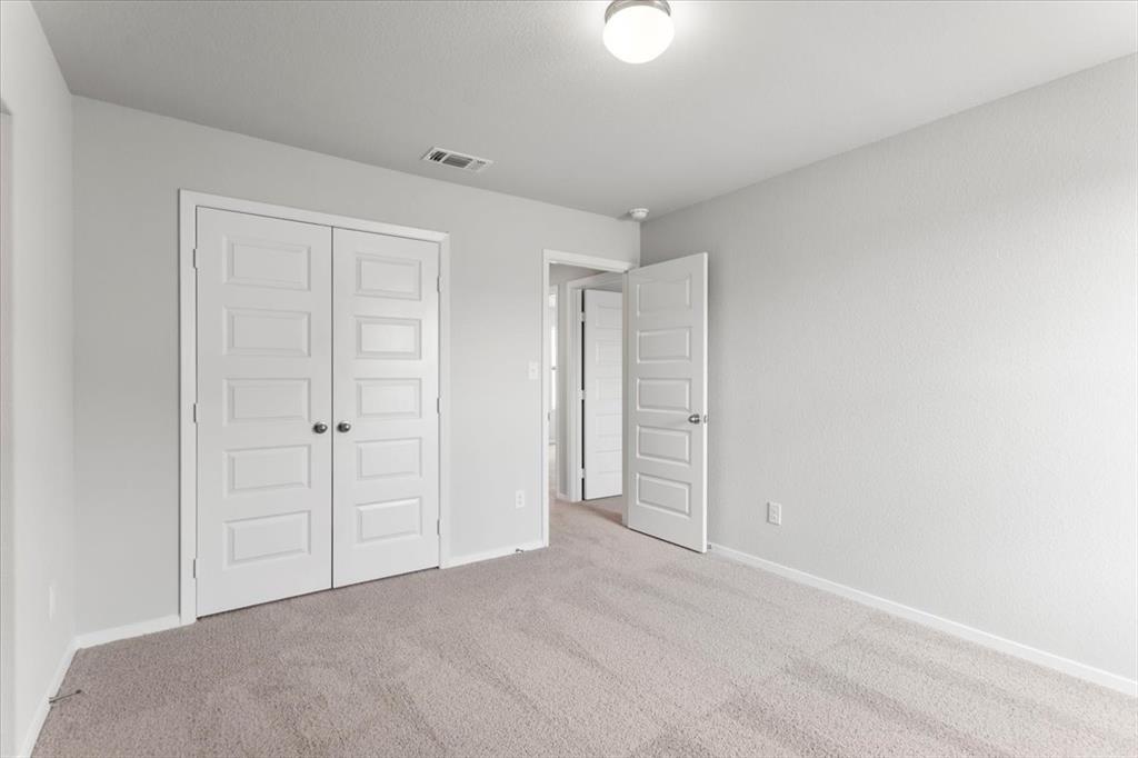 2707 Totley Road Manor, TX 78653 - Photo 29 of 39 Unfurnished bedroom with light carpet and a closet