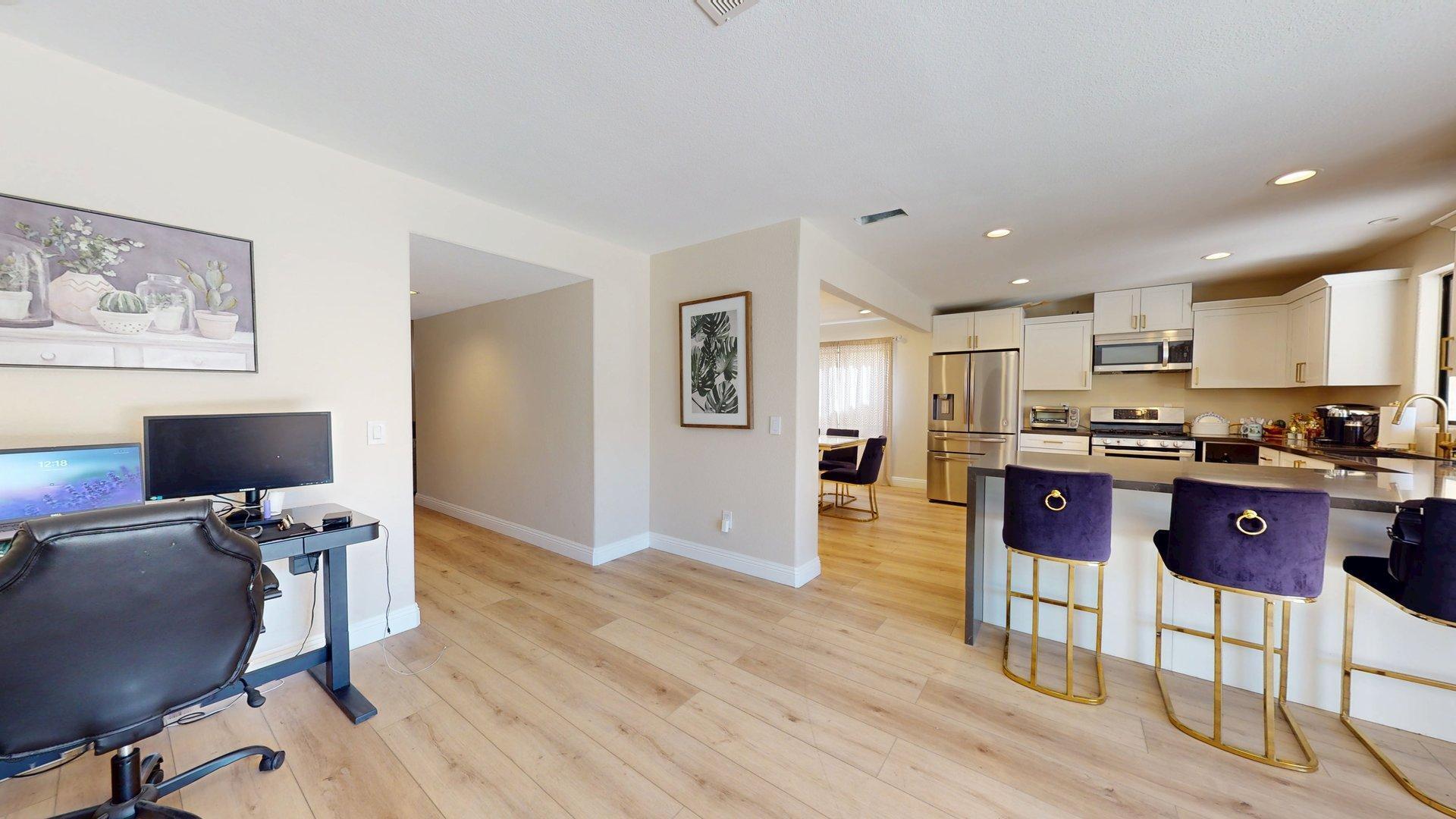 68645 Panorama Road Cathedral City, CA 92234 - Photo 11 of 35 a kitchen with stainless steel appliances granite countertop a refrigerator a stove top oven and a dining table with wooden floor