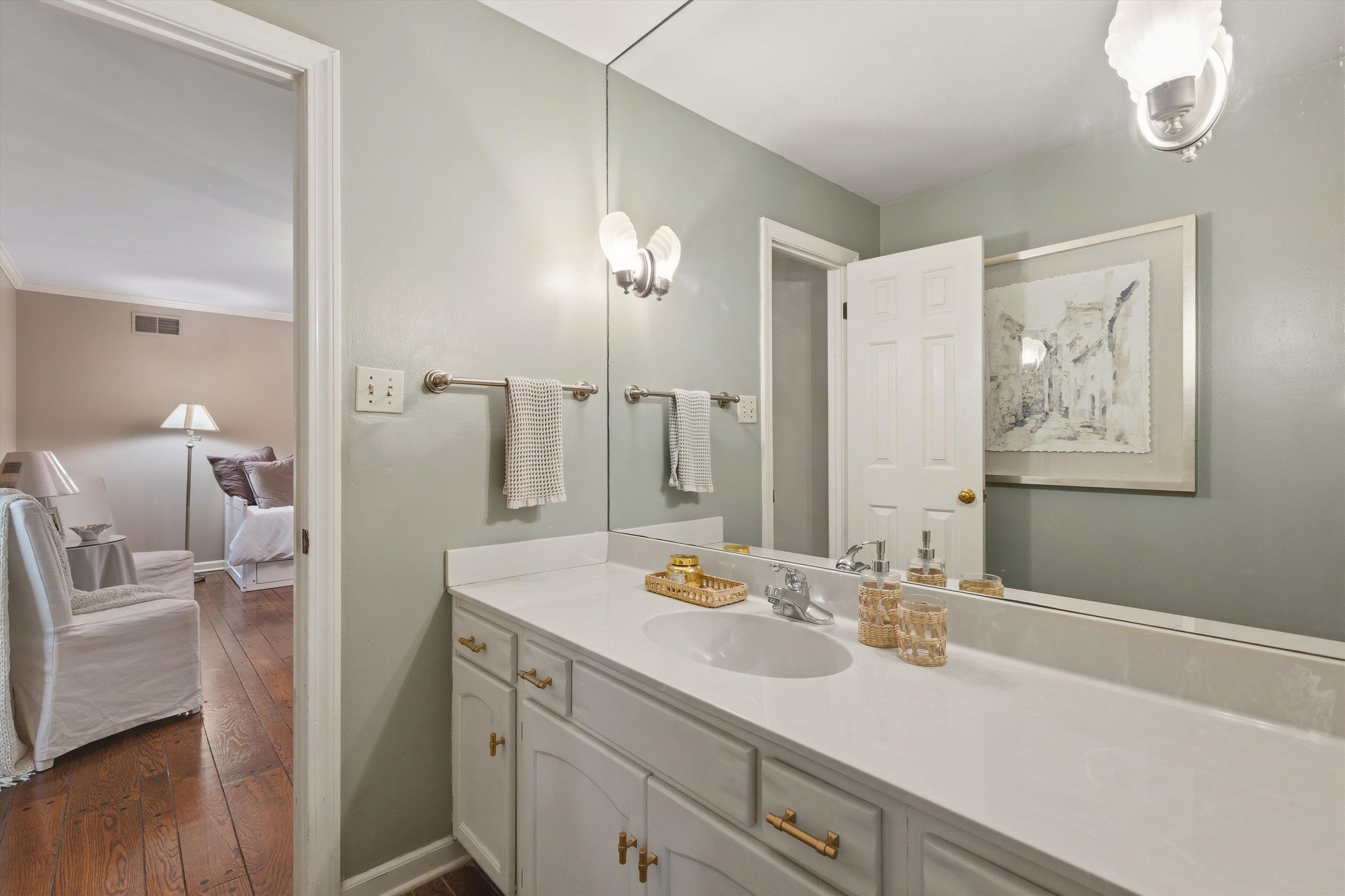 5828 Haymarket Road Memphis, TN 38120 - Photo 35 of 40 Bathroom vanity featuring a white countertop, integrated sink, and white cabinetry with brass-finish hardware