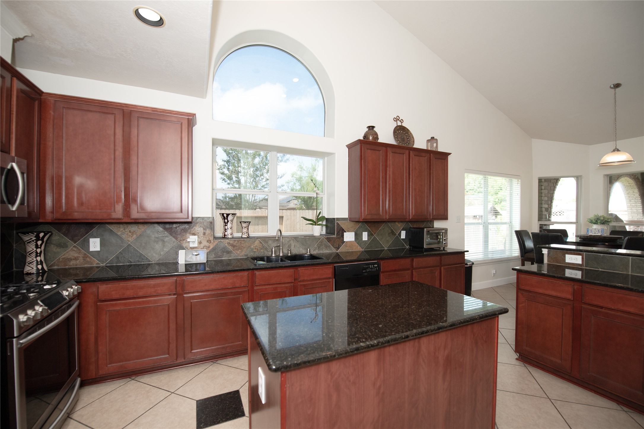 1914 Lakeside Crossing Katy, TX 77494 - Photo 16 of 44 a kitchen with granite countertop a sink stove and cabinets