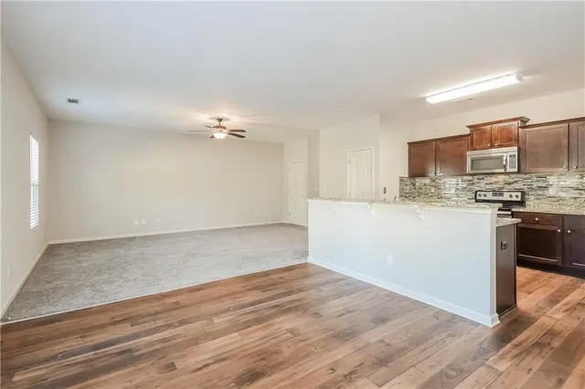 a view of kitchen with granite countertop cabinets and stainless steel appliances