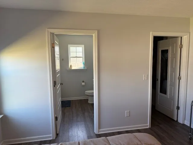 a view of a room that has a large window and wooden floor