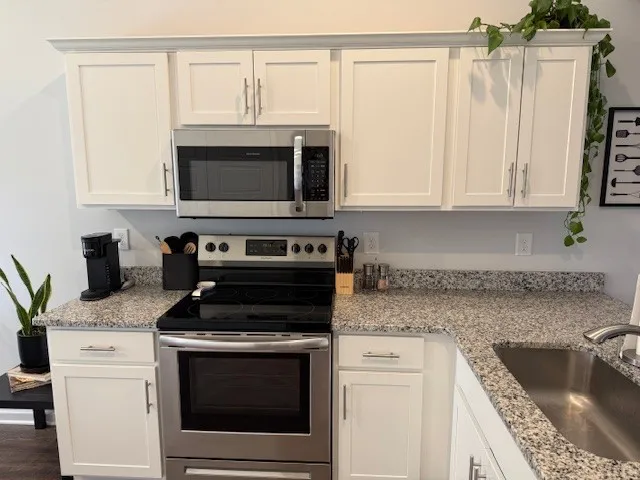 a kitchen with granite countertop a stove and a sink