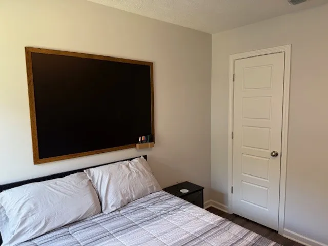 a bedroom with a bed tv and a window