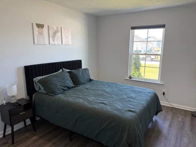a bed room with a bed and a painting on the wall