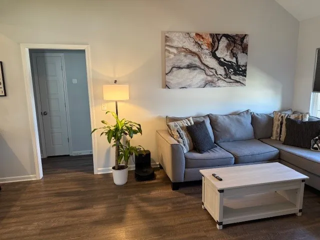 a living room with furniture and wooden floor