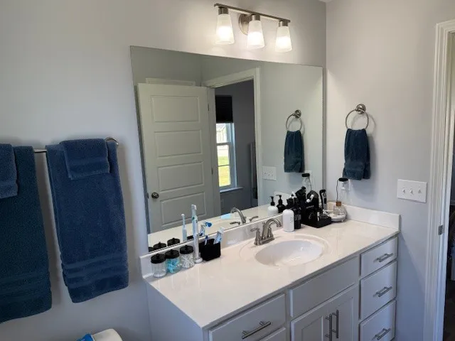 a bathroom with a sink vanity and mirror