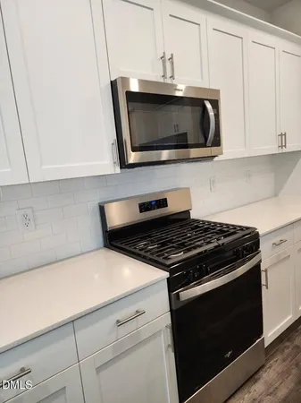 a kitchen with stainless steel appliances a stove microwave and sink