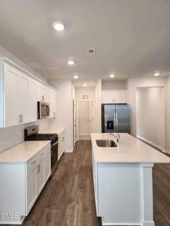 a kitchen with stainless steel appliances a sink stove and refrigerator