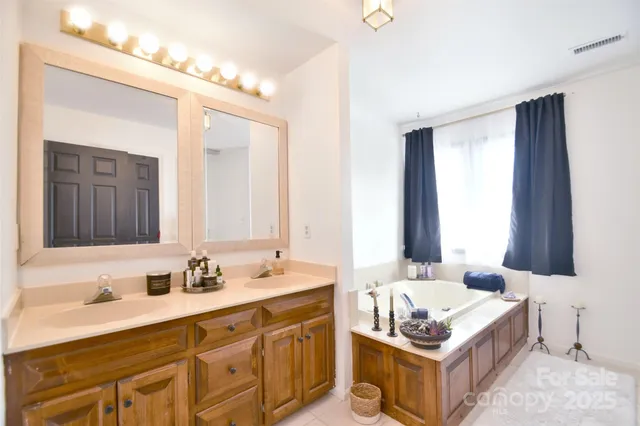 a spacious bathroom with a granite countertop double vanity sink a mirror and a