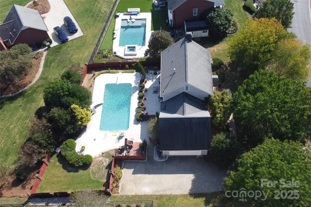 an aerial view of a house with a yard and basket ball court