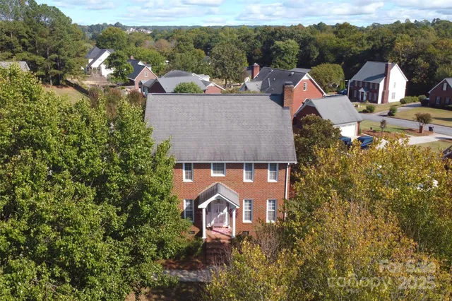 an aerial view of a house with a garden and mountains