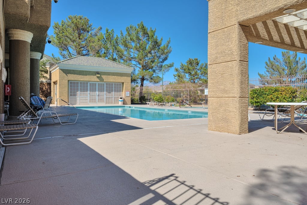 8025 West Russell Road, Unit 1090 Las Vegas, NV 89113 - Photo 21 of 23 A sparkling community pool sits framed by stucco pillars and sun-drenched concrete decking.