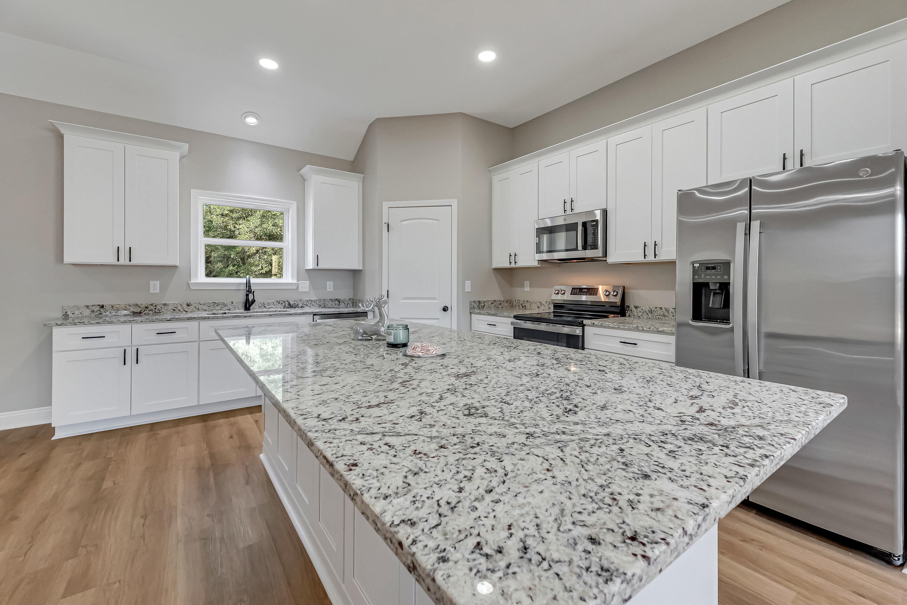 2.93-ac Goodwin Road Crestview, FL 32539 - Photo 6 of 45 a kitchen with stainless steel appliances granite countertop a sink stove refrigerator and a granite counter tops with wooden floors