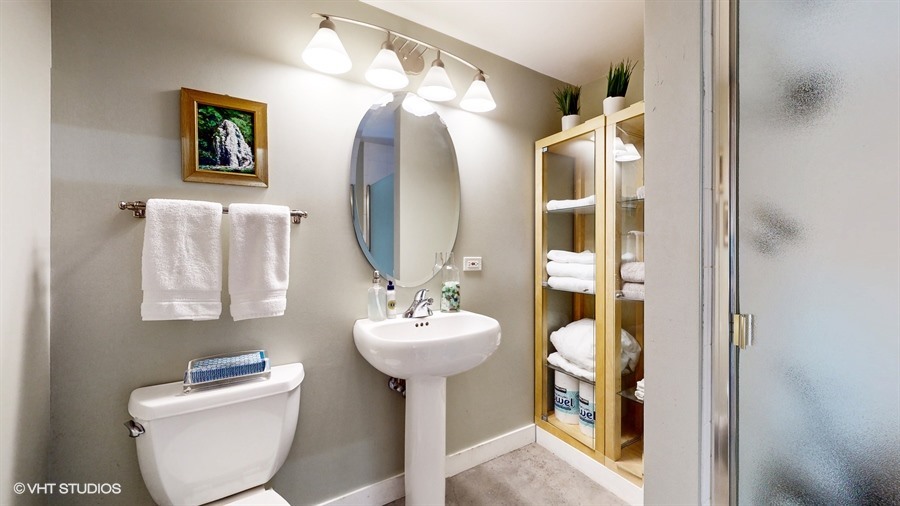 949 West Madison Street, Unit 401 Chicago, IL 60607 - Photo 12 of 14 a bathroom with a toilet sink and mirror