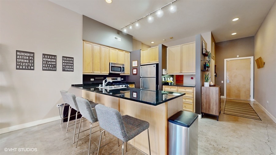 949 West Madison Street, Unit 401 Chicago, IL 60607 - Photo 5 of 14 a kitchen with stainless steel appliances granite countertop a stove and a refrigerator