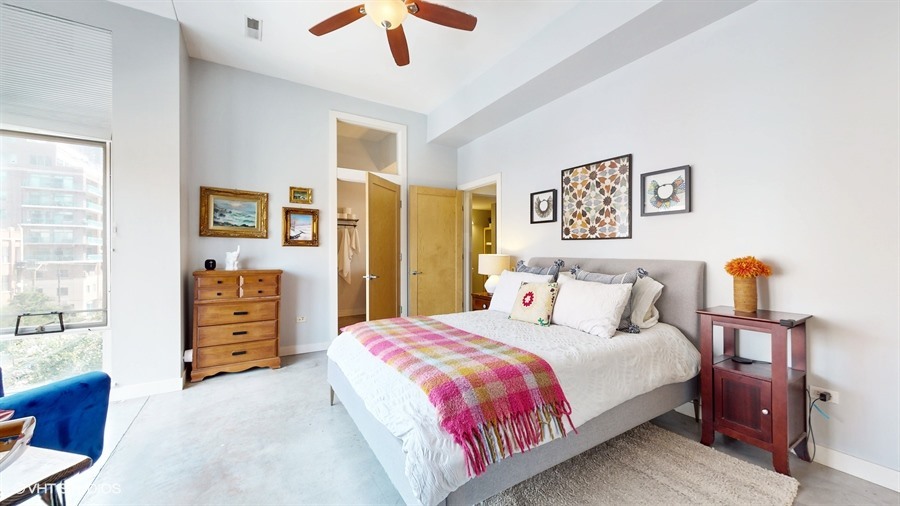 949 West Madison Street, Unit 401 Chicago, IL 60607 - Photo 8 of 14 a bedroom with a bed and a dresser