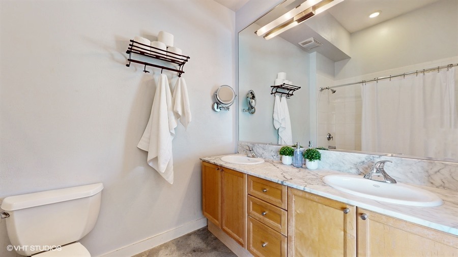 949 West Madison Street, Unit 401 Chicago, IL 60607 - Photo 9 of 14 a bathroom with a double vanity sink mirror and toilet