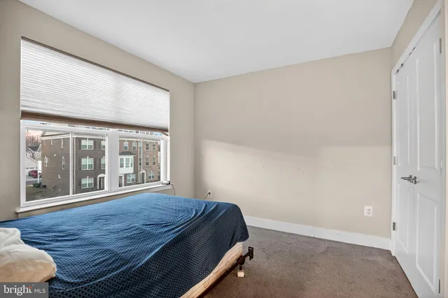 a bedroom with a bed and a large window