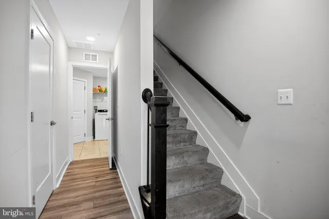 a view of a hallway with wooden floor and entryway