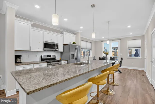 a kitchen with stainless steel appliances granite countertop sink microwave and wooden floor