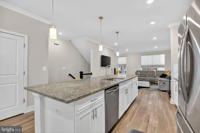a kitchen with stainless steel appliances granite countertop sink stove and refrigerator