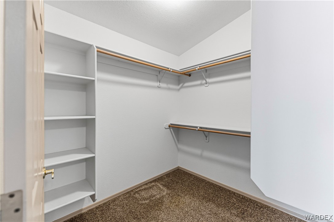 3973 Prairie View Drive Kingman, AZ 86409 - Photo 21 of 34 Walk-in closet featuring built-in shelving, hanging rods, and carpet flooring