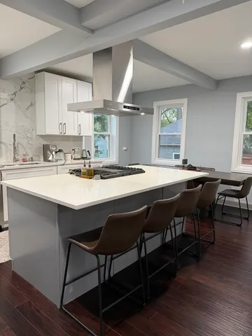 a kitchen with a dining table chairs and wooden floor
