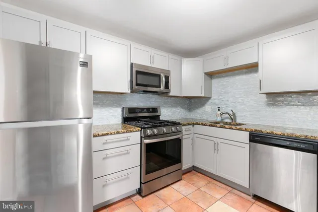 a kitchen with cabinets stainless steel appliances and a sink