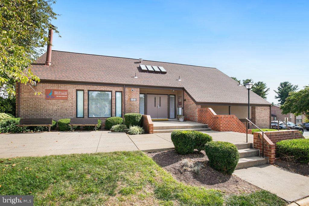 19027 Mills Choice Road, Unit 4 Gaithersburg, MD 20886 - Photo 23 of 26 a front view of a house with a yard and potted plants