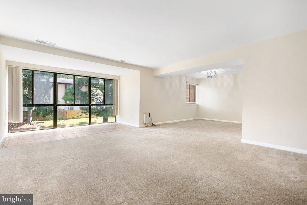 19027 Mills Choice Road, Unit 4 Gaithersburg, MD 20886 - Photo 4 of 26 an empty room with floor to ceiling window and an outdoor view