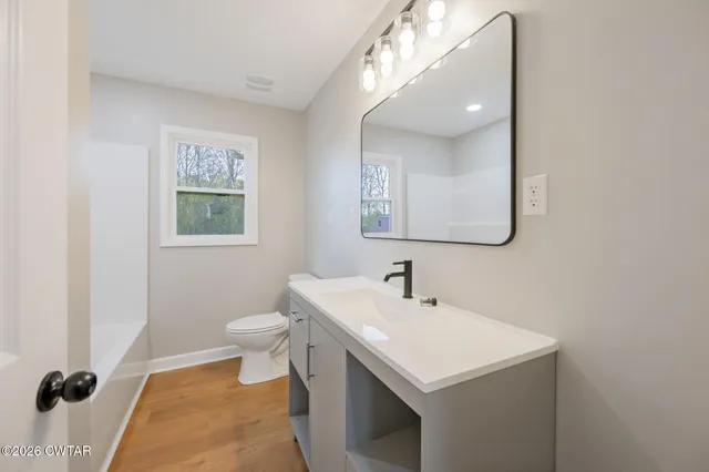 a bathroom with a sink toilet and mirror