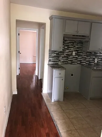 a kitchen with granite countertop a sink and cabinets